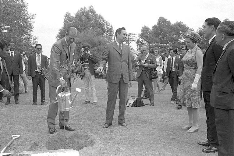 Duke of Edinburgh Prince Philip planting a tembusu tree at Jurong Hill as Queen Elizabeth II, Chairman of Jurong Town Corporation (JTC) Woon Wah Siang (centre), Minister for Culture Jek Yeun Thong (second from right) and other officials look on.