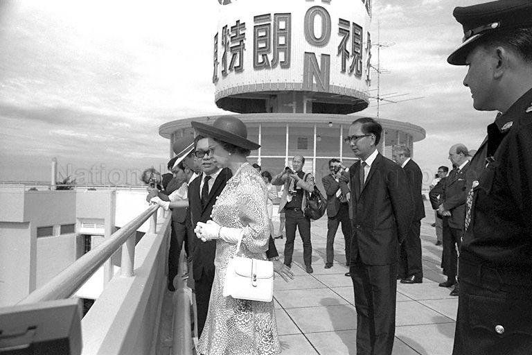 Queen Elizabeth II, accompanied by Chairman of Housing and Development Board (HDB) Lee Hee Seng, at the viewing gallery on the rooftop of Block 53, Toa Payoh Lorong 5, during her visit to the housing estate<br />