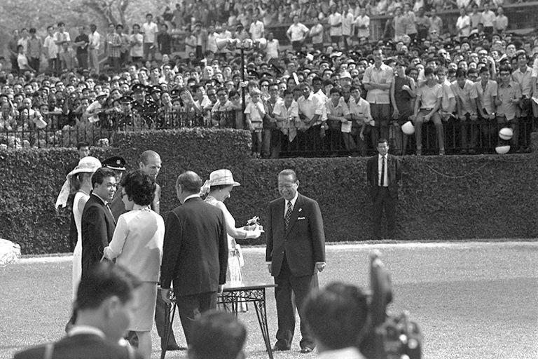 Queen Elizabeth II receiving a golden statuette of a racehorse as souvenir from Chairman of Singapore Turf Club Tan Sri Runme Shaw, after presenting prizes of the Queen Elizabeth II Cup. Looking on are (from right to left) club secretary D R H Brown (back to camera), Duke of Edinburgh Prince Philip, Mrs Shaw and Princess Anne.