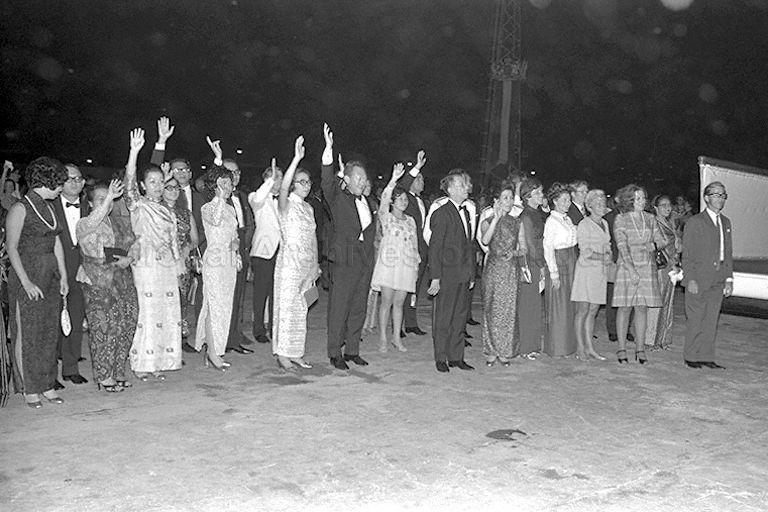 President and Mrs Benjamin Sheares, Prime Minister and Mrs Lee Kuan Yew, ministers and dignitaries and their wives waving farewell to the royal family as the royal yacht Britannia leaves the pier. Queen Elizabeth II was on a three-day visit to Singapore.