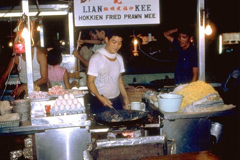 Hawker stall selling Hokkien fried prawn mee at old Glutton's Square, opposite Cold Storage (now Centrepoint) at Orchard Road. The space that the hawker stalls occupied at night was a car park by day, and is where Orchard Central is located currently.