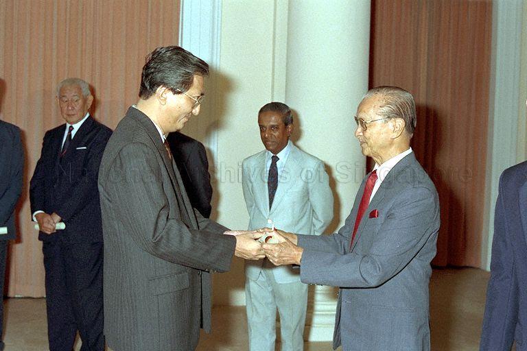 Chua Gim Siong receiving Instrument of Appointment as member of Presidential Council for Religious Harmony from President Wee Kim Wee at Istana. Minister for Law and Home Affairs S Jayakumar (in light grey suit) and Chief Justice Yong Pung How (hidden) were witnesses for the ceremony.