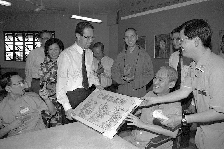 President Ong Teng Cheong, accompanied by First Lady Mrs Ong Siew May receiving a souvenir from a patient during a tour at the Ren Ci hospital at Buangkok Green. Joining the President and First Lady is Chairman of Ren Ci hospital, Venerable Shi Ming Yi.