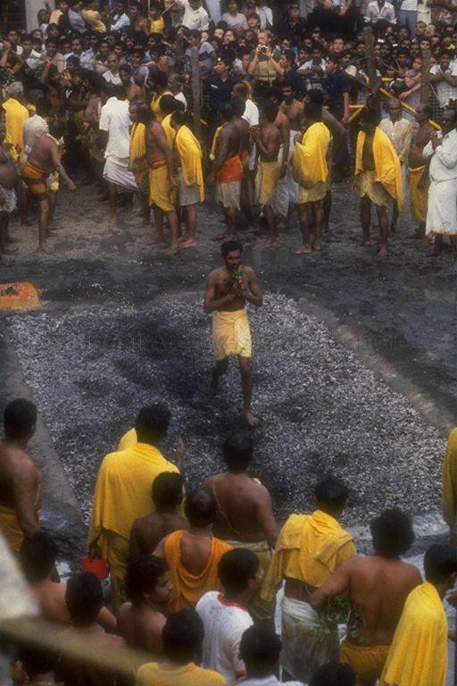 Hindu devotees briskly crossing a bed of burning coals to fulfil a vow to the Goddess of goodness and purity, Draupadi Amman, at Theemithi or fire walking ceremony held at Sri Mariamman Temple in South Bridge Road