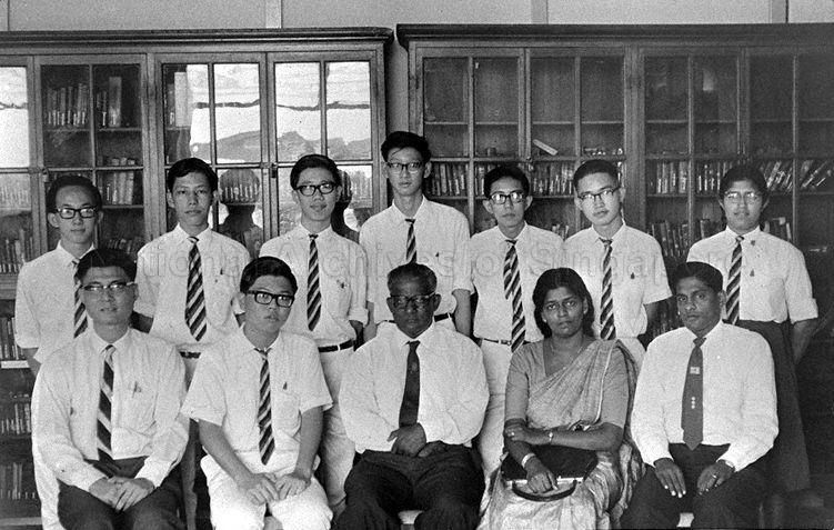 Group photograph of THE INDICATOR Editorial Board at Raffles Institution: (front row, left to right) Wong Hee Sing, Lim Chin Hian, E W Jesudason (Principal), Mrs Sigamoney, V Gomez; and (back row, left to right) Yip Mang Meng, Lee Yock Suan, Wong Heng Tem, Lee Choon Huat, Goh Kim Soon, Ong Geok Hwee, Mehta Minakshi