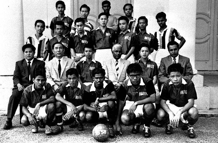 Group photograph of Raffles Institution Senior Football (1957) 1st team. Seated third from right is Principal V Ambiavagar. Present are (front row): Ansari Madar, Ho Ah Siew, Nadesan Chandran, Mohd Nor Samad, Chiam Toon Thong. Second row: Teachers Tan Kim Chye and Lim Teng Law, Farid Onn, Principal V Ambiavagar, Wong Wi Fong, teacher S S Sidhu. Third row: Ong Geok Seng, Phua Swan Kim, Low Meng Soon, Wong Toon Wah, Low Lip Ping, Mohd Said Samad, Kukundam. Fourth row: Chan Peng Soon, Wong Kong Yang, Thomas Joseph, and Yaacob Samad.