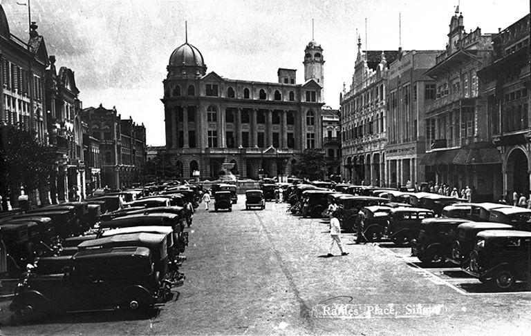 View of Raffles Place looking towards Chartered Bank building, Singapore . To the right and behind the Chartered Bank Building is the tower of Guthrie and Company's head office building.