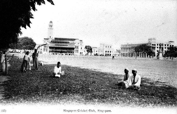 View of the Padang, with (from left) the clock tower at Victoria Memorial Hall, Singapore Cricket Club pavilion, Old Court House (now The Arts House), and Grand Hotel de l'Europe (now stands former Supreme Court building; soon to become National Art Gallery of Singapore) in the background. The statue of Sir Stamford Raffles can be seen on the right, at its very first location.