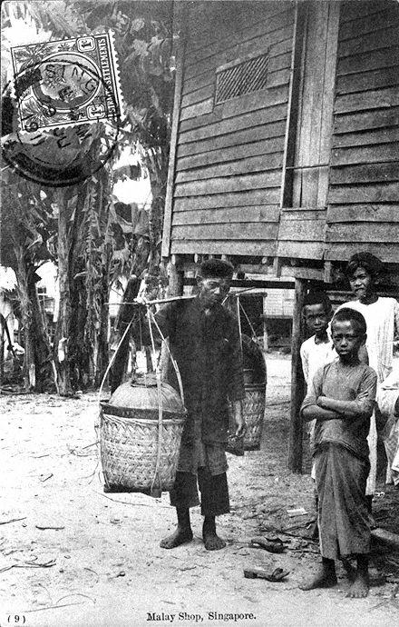 Malay "kueh" or cakes hawker carrying his wares and Malay boys in a "kampong" or village, Singapore