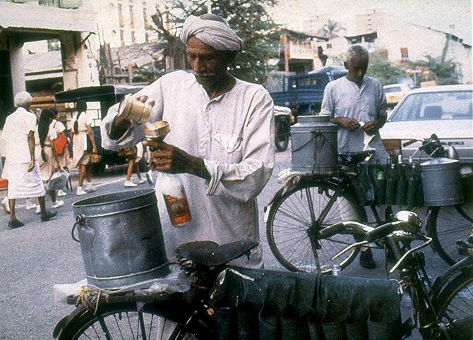 Indian man selling goat's milk from a bicycle at Serangoon Road in Little India