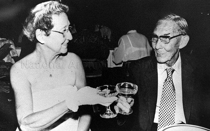 Well-known sports couple Mrs Alice Pennefather and Lancelot M Pennefather toasting each other at the Singapore Girls' Sports Club 50th anniversary celebration. Mr Pennefather represented Singapore in the Malayan Cup Soccer series in the 1920s while his wife was national champion in badminton and tennis in the 1930s. Mrs Alice Pennefather had also captained the Girls' Sports Club hockey team between 1931 to 1958.