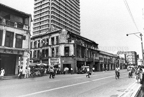 Junction of Hock Lam Street and North Bridge Road with iconic Bata Shoes building and Capitol theatre in the background. The new high rise building in the picture is Peninsula Hotel.