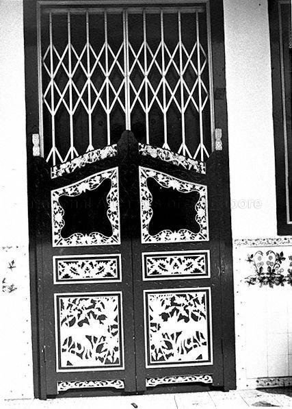 Pintu pagar' or fence door of the front entrance of a shophouse. These doors afford some measure of privacy when main doors are open for ventilation. Collapsible metal grilles also ensured security even when doors were wide open. Patterned ceramic tiles adorned the floor and wall up to waist-height around the entrance.
