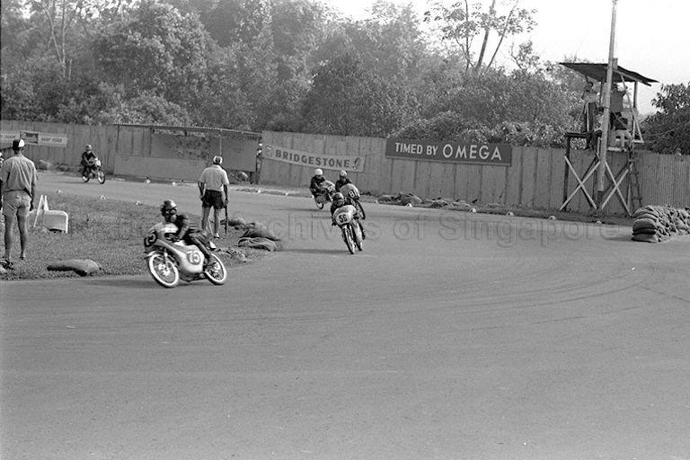 Lee Wing Sang on a 50cc Honda CR 110 leading the race round the Sembawang Circus, followed by Lionel Chan on a Suzuki, Ou Teck Wing on a Yamaha and a Japanese rider on a Bridgestone during Singapore Grand Prix 1966