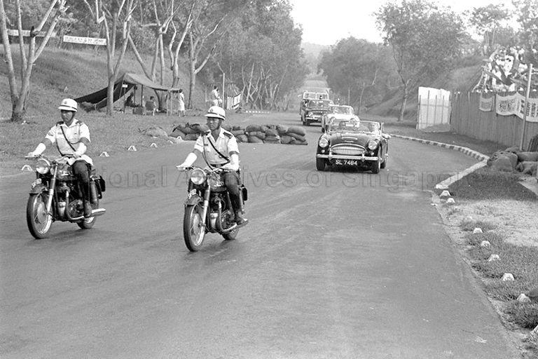 Cavalcade with police outriders on Norton motorcycles escorting President Yusof Ishak exiting the chicane on Sembawang, approaches the main grandstand at Sembawang Circus, during Singapore Grand Prix 1966 held at Thomson Road circuit