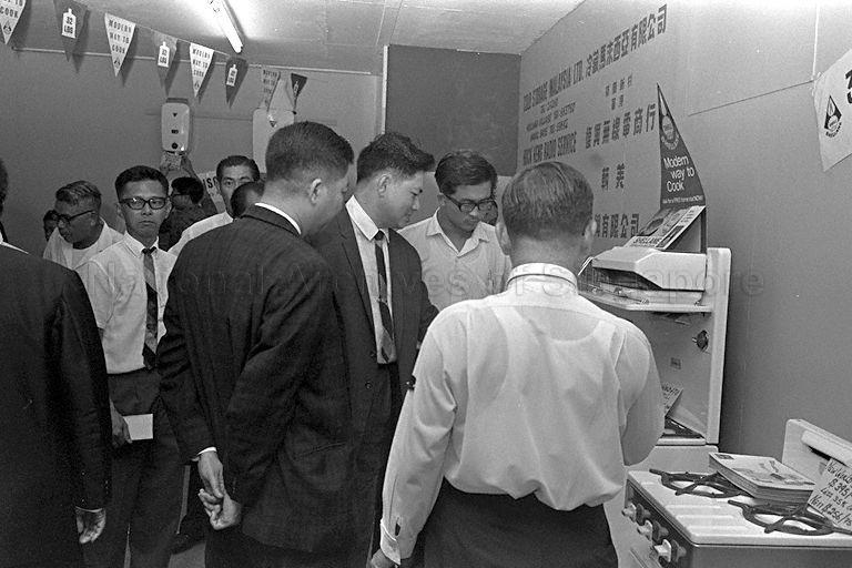 Parliamentary Secretary to Ministry of Social Affairs Chan Chee Seng (in suit and tie) touring the trade fair featuring Singapore-made goods and imported goods at Gay World during its opening.