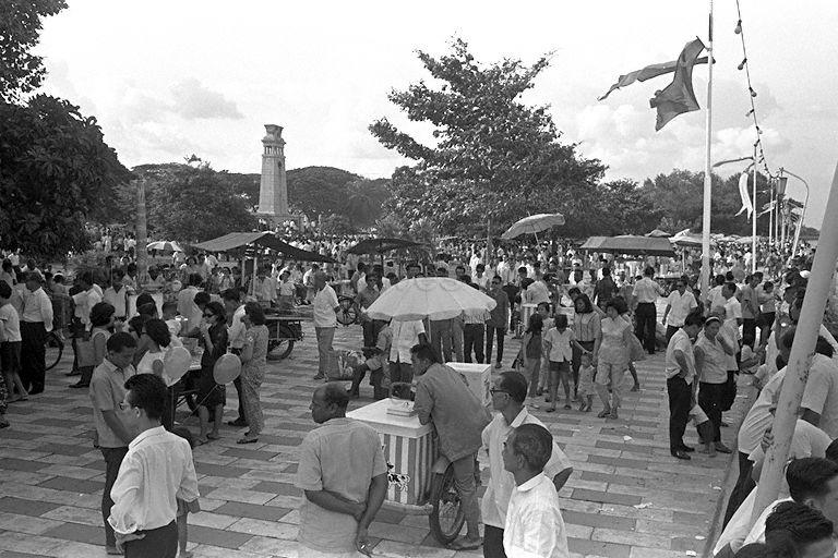 National Day Parade 1966 at the Padang - Hawkers and crowd along Queen Elizabeth Walk at the Esplanade before the late afternoon display of fireworks