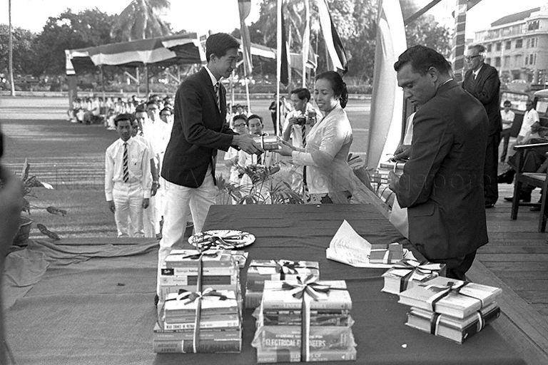 Prefect Low Ching Ming receiving his prize from wife of Minister for Culture and Social Affairs Mrs Othman bin Wok during Raffles Institution's Speech Day prize giving ceremony
