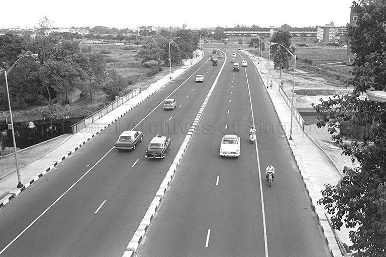 View of Mountbatten Road crossing over Geylang River, looking towards Old Airport Road traffic circus. Kallang Park is on the left, while a three-storey building in the right background is Kallang Primary School. Part of Dakota Close flats is also visible on far right.