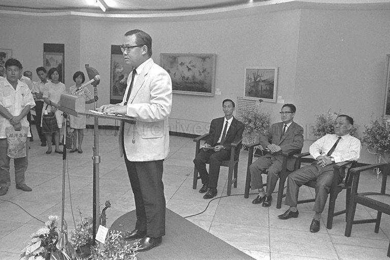 President of Singapore Art Society Ho Kok Hoe speaking at opening of Lee Man Fong's art exhibition at Victoria Memorial Hall. Seated from right are Minister of State for Culture Lee Khoon Choy (first) and artist Lee (second).