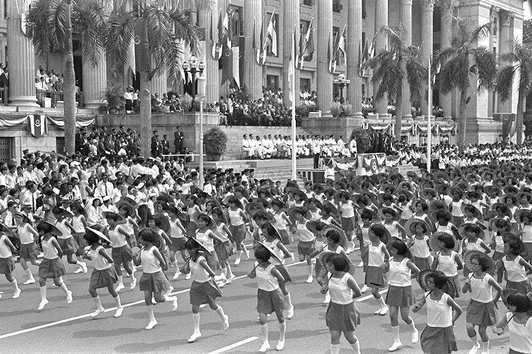 National Day Parade 1967 at the Padang - Students performing "umbrella" dance, one of few cultural dances presented separately by five schools, in front of City Hall
