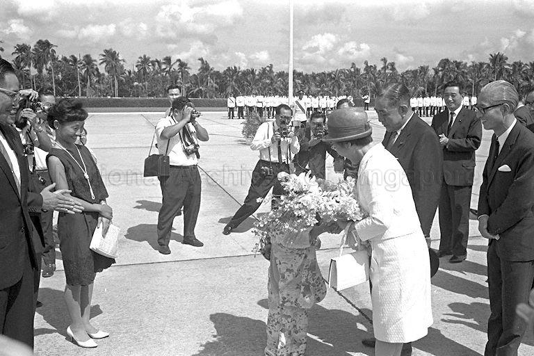Japanese Prime Minister Eisaku Sato (second from right) and his wife Mrs Hiroko Sato (wearing a hat) are presented with a bouquet of flowers at Paya Lebar Airport.