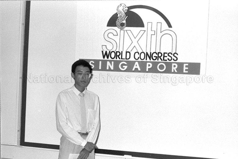 Winner of Direct Selling Association of Singapore (DSAS) logo competition, which is held in conjunction with Sixth World Congress to be hosted in Singapore. Behind him is the winning logo.