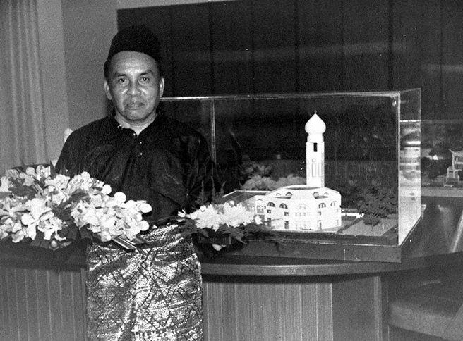 Member of Al-Muttaqin Mosque in Ang Mo Kio posing by model of the mosque during its official opening