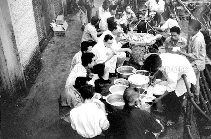Food hawkers and customers along Singapore River