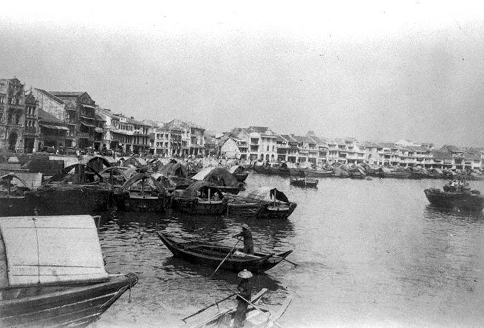Bumboats and sampans at Singapore River with shophouses and godowns along the banks