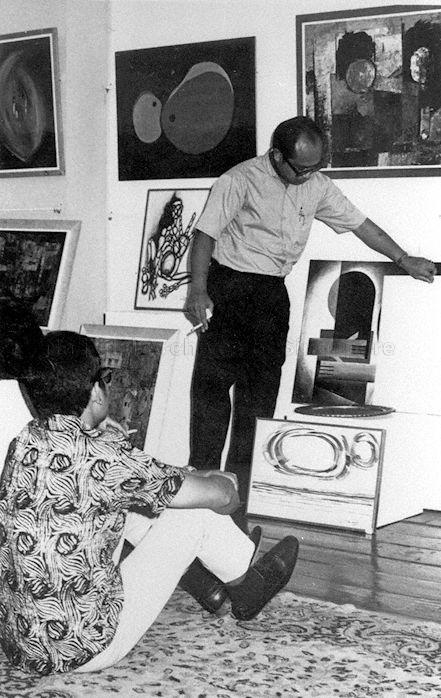 President of Angkatan Pelukis Aneka Daya (APAD), or Association of Artists of Various Resources, Abdul Ghani Hamid (standing), who contributed this photograph, displaying art pieces at the Malay Art Gallery at Bussorah Street