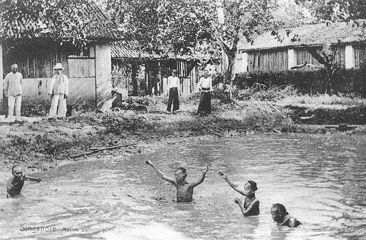 Chinese boys with pigtails tied up on top of their heads bathing in a village stream