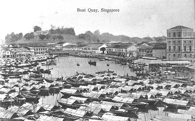 View of Boat Quay looking towards Fort Canning Hill, Singapore. The covered landing stage on the right was the site of the original Hallpike Boatyard where boat building and repairs were carried out from 1823 to late 1860s.