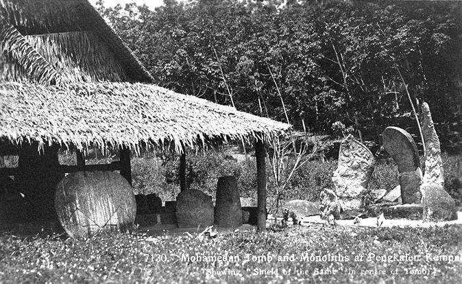 Muslim tomb and megaliths at Pengkalan Kempas, Negeri Sembilan, Federated Malay States. The 15th century tomb is believed to be the oldest Muslim grave in Malaya and was known as Keramat Sungai Udang in the old days. The three megaliths on the right were named, from left, 'rudder', 'spoon' and 'sword' due to their resemblance to the objects. The 'Shield of the Saint' is on the left.