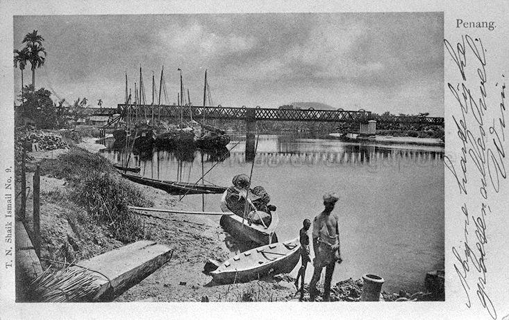 Sampans and junks near the railway bridge over Kerian River at Nibong Tebal, Penang. With the extension of the Prai Railway to Nibong Tebal, the Kerian railway bridge was constructed to connect the town to Parit Buntar in Perak. It was demolished in the 2000s.