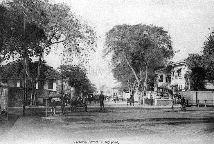 View along Victoria Street, Singapore, at junction with Stamford Road. Part of Hotel van Wijk can be seen on the right.