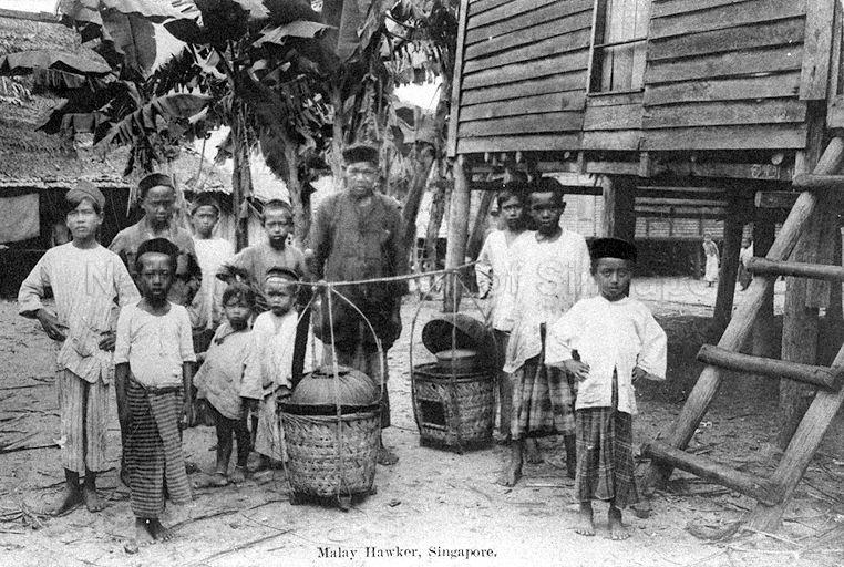 Malay "kueh" or cakes hawker carrying his wares and Malay boys in a "kampong" or village, Singapore