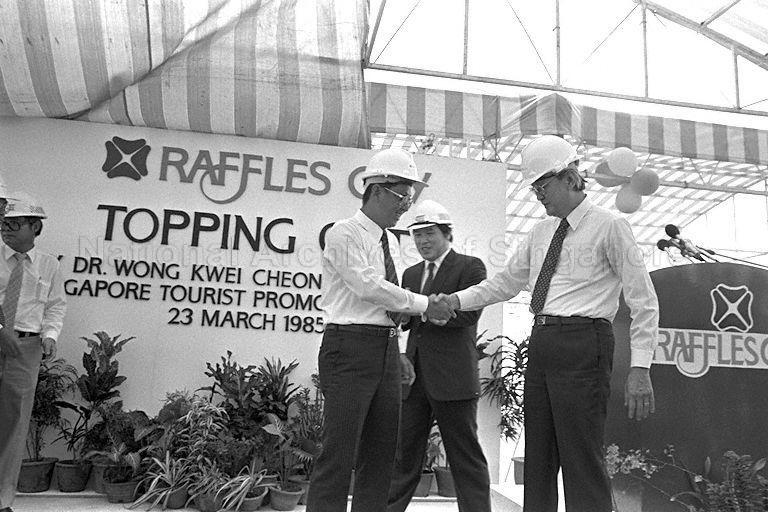 Singapore Tourism Board Chairman Dr Wong Kwei Cheong (left) shaking hands with Raffles City Pte Ltd Chairman Chua Kim Yeow (right) at the topping-out ceremony of Raffles City. Also present is Ssangyong Construction Co. Ltd President Kim Suk Joon (centre).