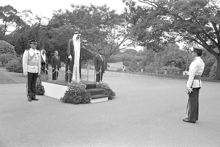 Ambassador of Qatar to Singapore Dr Hassan Ali Hussain (standing on stage) reviewing the guard of honour contingent at the Istana.