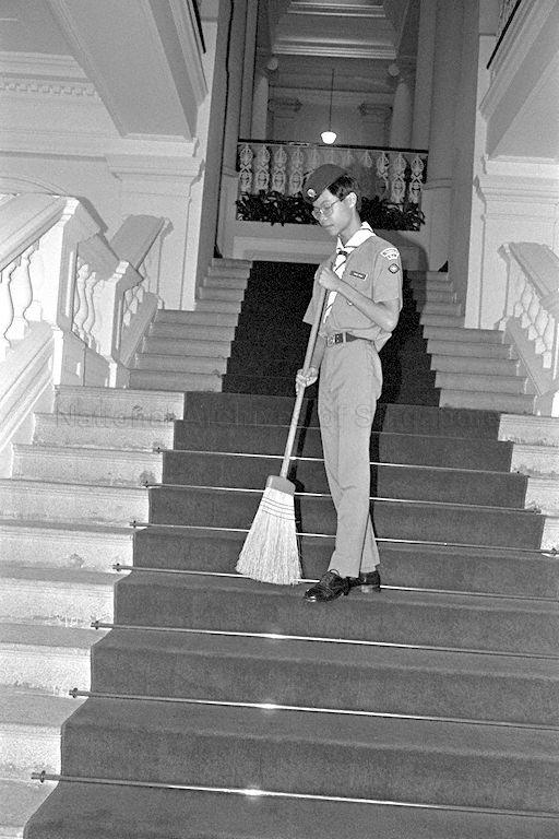 Colin Tham Hsien Jen from Anglo Chinese School brushing down the red carpet at Istana where President Wee Kim Wee, Chief Scout of Singapore, launches Scout Job Week to raise funds for the scouts' training programme and activities.