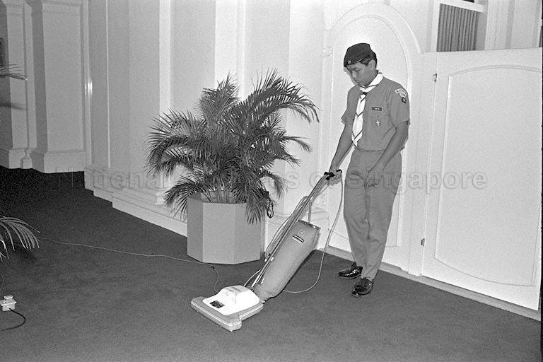 John Pok Liwen from Anglo Chinese School vacuuming the red carpet at Istana where President Wee Kim Wee, Chief Scout of Singapore, launches Scout Job Week to raise funds for the scouts' training programme and activities.