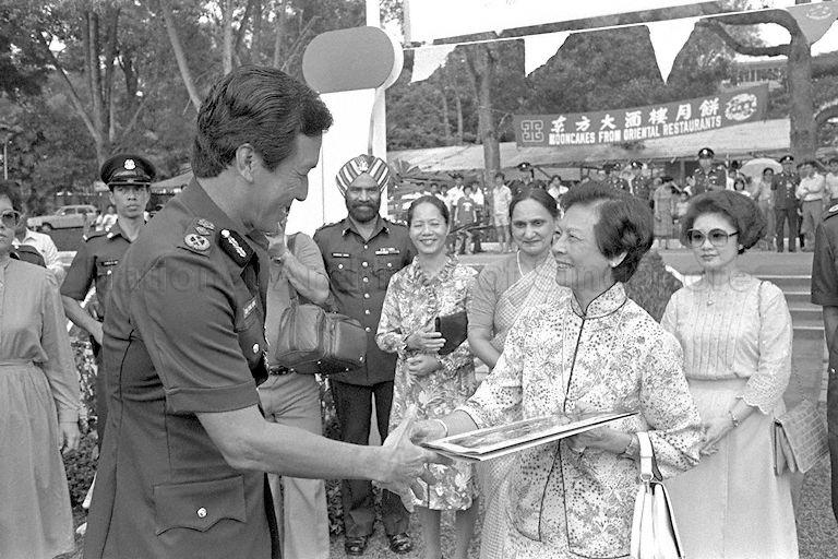 First Lady Madam Koh Sok Hiong (right, foreground) shaking hands with a policeman during the Police Carnival and Display 1985 event at the Police Academy at Thomson Road.