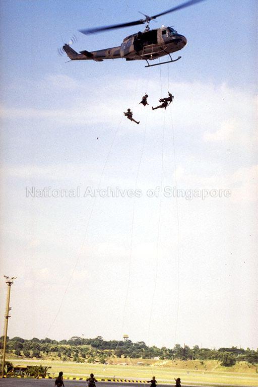 Guardsmen rappelling from UH-1 helicopter at Singapore Armed Forces (SAF) exhibition "SAF at 25" at Paya Lebar Airport. The exhibition is organised by the SAF Combat Engineers as part of the SAF's silver jubilee celebrations, and gives an insight into the history of the SAF and how it might evolve in the future.