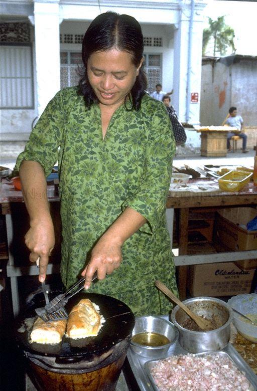 Hawker making Roti John.