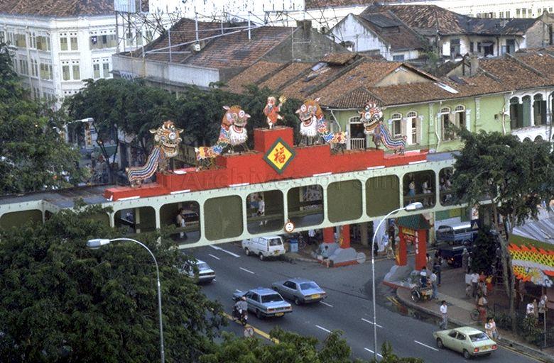 The overhead pedestrian bridge that links People's Park Complex to Pagoda Street (right) decorated for Chinese New Year with lion dance figures. &nbsp;In the background is a newly restored building which was a former Singapore Improvement Trust (S.I.T.) block for rental only in the 1930s.