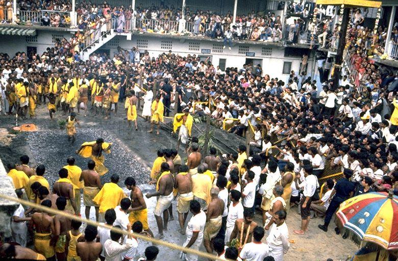Devotees walking across burning coals during Theemithi at Sri Mariamman Temple