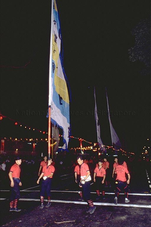 Performers balancing the giant flag with acrobatic stunts during the first night-time Chingay parade at Orchard Road