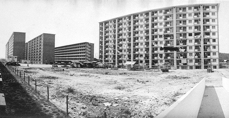 Blocks of 10-storey Housing and Development Board (HDB) flats (colloquially called "chap lau chu" in Hokkien dialect) surrounding a vacant plot of sandy land in Queenstown (Singapore's first satellite town) neighbourhood