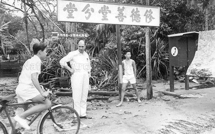 Sign reading "Branch of Seu Teck Sean Tong". A telephone booth stands on the right.