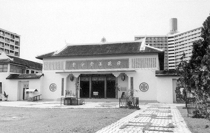 Seu Teck Sean Tong in Toa Payoh. This temple was an attap hut when it was first constructed in the Mid-Autumn of 1942, until reconstruction work  started around 1954 and it was reopened in 1959. The charity hall was also part of Blue Cross Charitable Institutions, which explains the presence of a cross symbol on the facade. The tall Housing & Development Board (HDB) building in the background is Block 53 of Lorong 5 Toa Payoh, which was the tallest structure in Toa Payoh new town until the 5-room point blocks were built later.